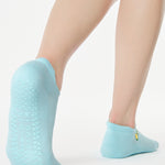 Women wearing a light blue full foot grip sock with a yellow lemon motif near the cuff made for Pilates, Barre, Yoga, and beyond. 