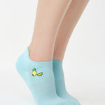 Women wearing a light blue full foot grip sock with a yellow lemon motif near the cuff made for Pilates, Barre, Yoga, and beyond. 