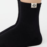 Woman wearing a solid black ankle grip sock with libra zodiac sign embroidered on the side. Made for pilates, barre, yoga, and beyond. 