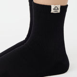 Woman wearing a solid black ankle grip sock with libra zodiac sign embroidered on the side. Made for pilates, barre, yoga, and beyond. 