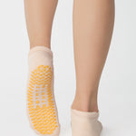 Women wearing an off white full foot grip sock with bananas string of red hearts , made for pilates, barre, yoga, and beyond.