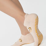 Women wearing an off white full foot grip sock with bananas string of red hearts , made for pilates, barre, yoga, and beyond.