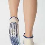 Women wearing an ombre white into light blue full foot grip sock with a navy blue ruffle cuff and inhale and exhale written on the top of the toes, made for pilates, barre, yoga, and beyond.