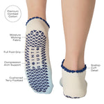 Women wearing an ombre white into light blue full foot grip sock with a navy blue ruffle cuff and inhale and exhale written on the top of the toes, made for pilates, barre, yoga, and beyond with product features listed. 