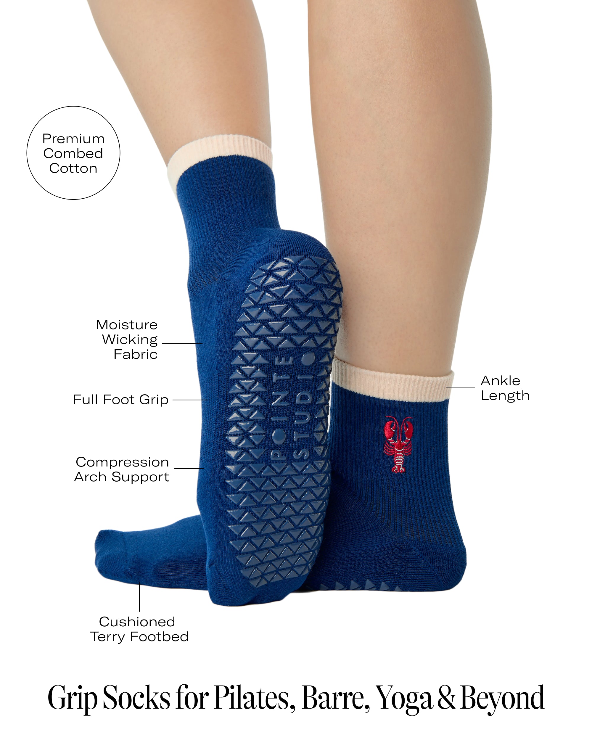 Woman wearing a solid navy blue ankle grip sock with a beige solid cuff and a red lobster embroidered on the ankle. Made for pilates, barre, yoga, and beyond. With a list of all the product details listed. 