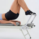 Woman on a reformer wearing a black full foot grip sock with woven suns, cacti, and snakes. Made for pilates, barre, yoga, and beyond. 