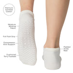 Women wearing a solid white full foot grip sock with a blue evil eye motiff on the top of the toes, made for pilates, barre, yoga, and beyond with a list of product features.