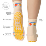 Women wearing an off white ivory ankle grip sock with a flower pattern wrapped around the ankle cuff and toes, made for pilates, barre, yoga, and beyond with a list of product features.
