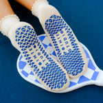 Women wearing off white ankle grip socks with blue happy face for Pilates, Barre, Yoga, and beyond. 