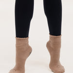 Women wearing brown ankle grip socks with black happy face for Pilates, Barre, Yoga, and beyond. 