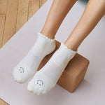 Women wearing white grip socks with green smiley face for Pilates, Barre, Yoga, and beyond.