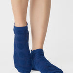 Women wearing blue smiley face patterned grip socks made for Pilates, Barre, Yoga, and beyond. 