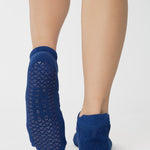 Women wearing blue smiley face patterned grip socks made for Pilates, Barre, Yoga, and beyond. 