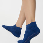 Women wearing blue smiley face patterned grip socks made for Pilates, Barre, Yoga, and beyond. 