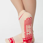 Women wearing a solid off white full foot grip sock with a string of red hearts , made for pilates, barre, yoga, and beyond.
