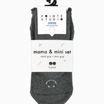 A 2 grip sock pack of charcoal grey full foot happy face styles one for a kid ages 4-7 and one matching for an adult. 