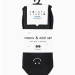 A 2 grip sock pack of black full foot happy face styles one for a kid ages 4-7 and one matching for an adult. 