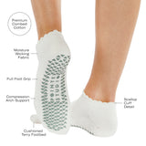 Women wearing white grip socks with green smiley face for Pilates, Barre, Yoga, and beyond with all features listed