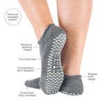 Women wearing gray grip socks with white smiley face for Pilates, Barre, Yoga, and beyond with all the features listed.