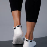Woman on yoga mat wearing a white sold color full foot grip sock with crows circling the cuff. Made for pilates, barre, yoga, and beyond.