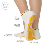 Woman wearing solid white strap grip sock with bumble bees wrapping around the scalloped cuff, made for pilates, barre, yoga, and beyond. With all the product features listed.