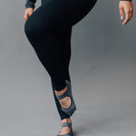 Woman wearing a solid charcoal grey strap grip sock, made for pilates, barre, yoga, and beyond. 
