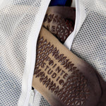 A small white mesh laundry bag for grip socks.