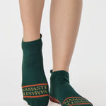 Woman wearing a green full foot grip sock with a yellow namaste message. Made for pilates, barre, yoga, and beyond. 