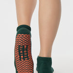 Woman wearing a green full foot grip sock with a yellow namaste message. Made for pilates, barre, yoga, and beyond. 