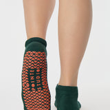 Woman wearing a green full foot grip sock with a yellow namaste message. Made for pilates, barre, yoga, and beyond. 