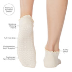 Women wearing a solid white full foot grip sock with a playful ruffle cuff made for Pilates, Barre, Yoga, and Beyond with the product features listed.