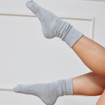 Women wearing a light blue mid-weight knit grip sock that scrunches, made for Pilates, Barre, Yoga, and Beyond. 