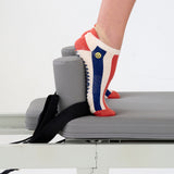 Woman on a pilates reformer wearing a playfully blue, white, and red stripped full foot grip sock with a little embroidered smiley face by the ankle. Made for pilates, barre, yoga, and beyond. 