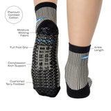 Woman wearing a black and white striped ankle grip sock with sardines swimming around the sock. Made for pilates, barre, yoga, and beyond. With a list of all the product features.