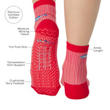 Woman wearing a red and white striped ankle grip sock with sardines swimming around the sock. Made for pilates, barre, yoga, and beyond. With all the product features listed. 