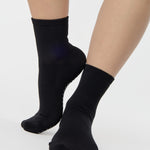 Women wearing a solid black ankle grip sock made for Pilates, Barre, Yoga, and beyond. 