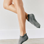 Women wearing a solid gray full foot grip sock made for Pilates, Barre, Yoga, and beyond. 