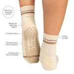 Women wearing a solid nougat white ankle grip sock with brown stripes on the toes and top ankle cuff made for Pilates, Barre, Yoga, and beyond with a list of features.