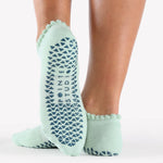 Women wearing baby blue grip socks with blue face for Pilates, Barre, Yoga, and beyond. 