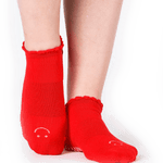 Women wearing red grip socks with white smiley face for Pilates, Barre, Yoga, and beyond. 