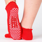 Women wearing red grip socks with white smiley face for Pilates, Barre, Yoga, and beyond. 