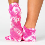 Woman wearing a hot pink full foot grip sock with it tie dyed white, made for pilates, barre, yoga, and beyond.  
