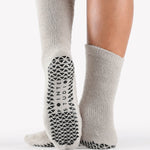 Women wearing grey fuzzy plush crew grip socks with a black happy face for recovery and relaxing.  