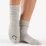 Women wearing grey fuzzy plush crew grip socks with a black happy face for recovery and relaxing.  