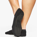 Woman wearing a black dance style strap grip cocktail, made for pilates, barre, yoga, and beyond. 