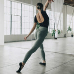 Woman wearing a black dance style strap grip cocktail, made for pilates, barre, yoga, and beyond. 
