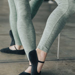 Woman wearing a black dance style strap grip cocktail, made for pilates, barre, yoga, and beyond. 
