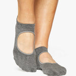 Woman wearing a solid charcoal grey strap grip sock, made for pilates, barre, yoga, and beyond. 